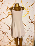 A sleeveless halter-neck dress in a light beige 