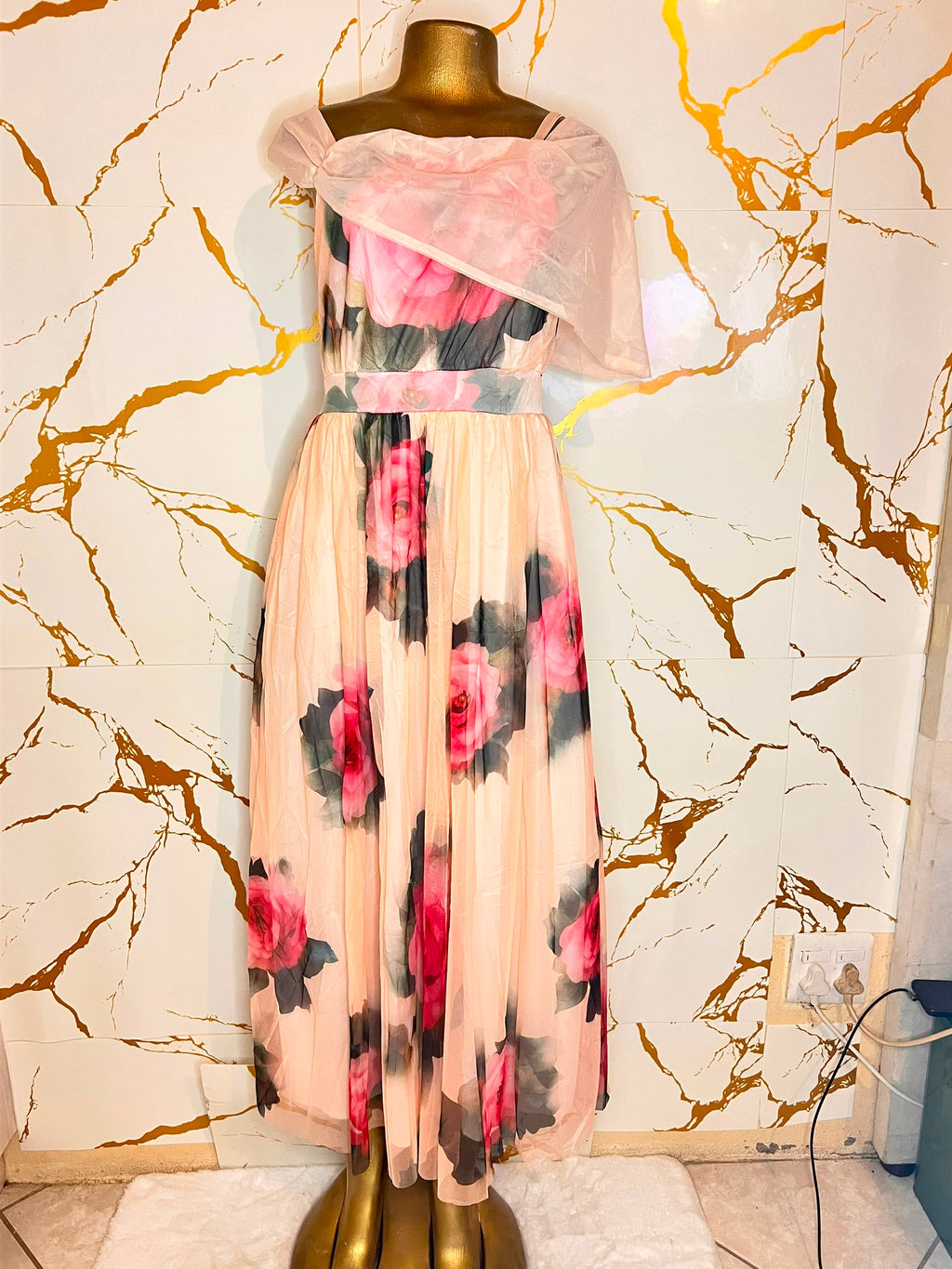 A peach-colored maxi dress with a pink and black floral print